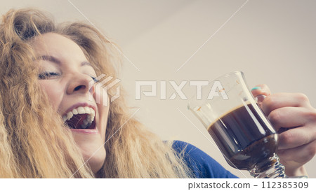 Positive woman drinking her morning coffee 112385309