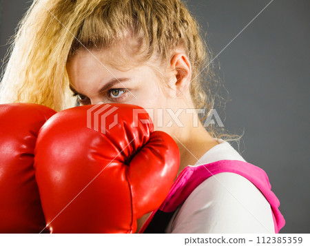Angry woman wearing boxing gloves Angry woman wearing boxing gloves 112385359