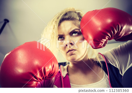 Angry woman wearing boxing gloves Angry woman wearing boxing gloves 112385360