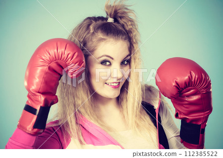 Funny girl in red gloves playing sports boxing Funny girl in red gloves playing sports boxing 112385522