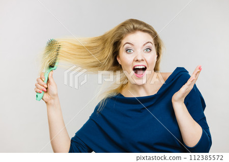 Woman brushing her long hair with brush Woman brushing her long hair with brush 112385572