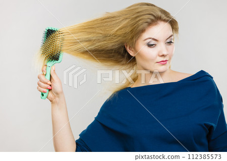 Woman brushing her long hair with brush 112385573