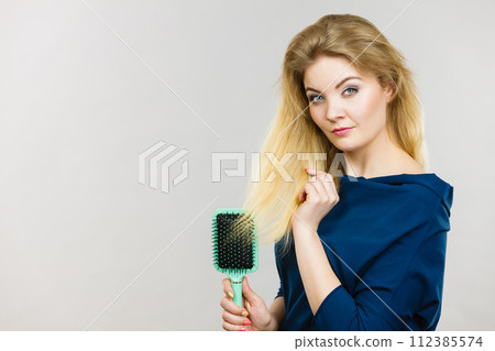 Woman brushing her long hair with brush Woman brushing her long hair with brush 112385574