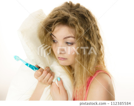 Sleepy woman hugging white pillow 112385584
