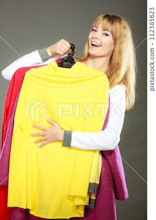 woman customer holding hangers with clothes woman customer holding hangers with clothes 112385623