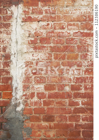 Old brick wall texture. The wall, made of old red bricks, darkened by old age. Ancient background. 112386190