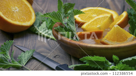 orange lemonade with soda water and mint, space for text. Fresh summer cocktail. 112386554