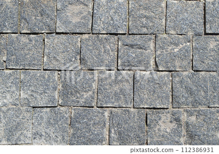 An old stone pavement. The old road. Stone masonry. Gray granite. Roads of the old city. An old stone pavement. The old road. Stone masonry. Gray granite. Roads of the old city. 112386931