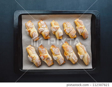 Delicious freshly baked pastries in a pastry shop. croissants on a baking sheet of a baking shop 112387821