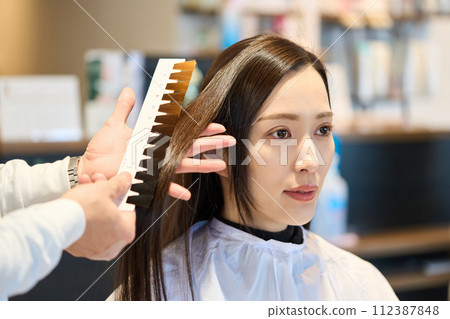 Hairdresser applying hair color chart Hairdresser applying hair color chart 112387848