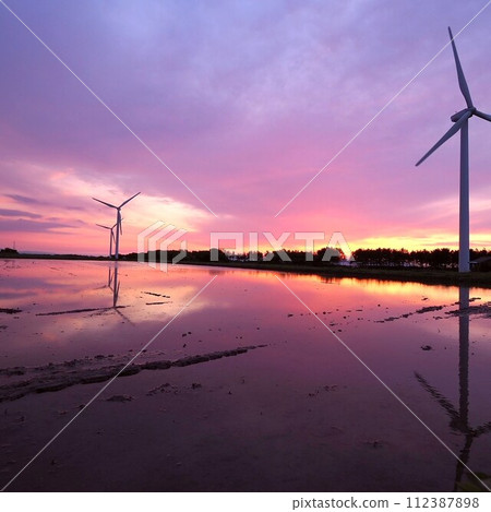 稻田和風車裡充滿了被夕陽染紅的水 稻田和風車裡充滿了被夕陽染紅的水 112387898