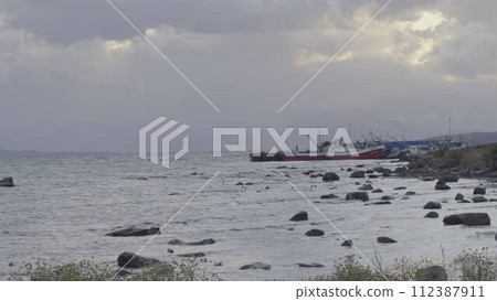Peaceful Fishing Boats Moored at Dusk by the Gentle Sea 112387911