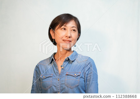 A woman wearing a casual shirt with a pendant and earrings 112388668