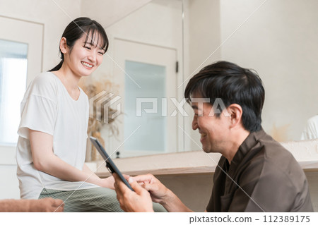 A woman receiving counseling at a chiropractic clinic/osteopathic clinic/massage and a chiropractor/therapist (tablet PC) A woman receiving counseling at a chiropractic clinic/osteopathic clinic/massage and a chiropractor/therapist (tablet PC) 112389175