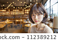 street snapshot image of beautiful Asian young woman with short hair sitting at cafe 112389212