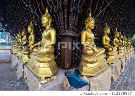 Rows of golden Buddha statue in Seema Malaka buddhist temple on Beira Lake in Colombo, Sri Lanka. Colombo is the commercial capital and largest city of Sri Lanka. 112389557