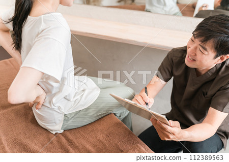 A woman who goes to a chiropractic clinic/osteopathic clinic/massage and a chiropractor/therapist (back pain) 112389563