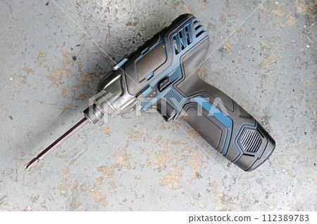 Battery screwdriver or drill placed on the floor Battery screwdriver or drill placed on the floor 112389783