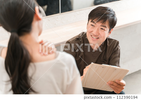 脊椎按摩師和治療師在脊椎按摩診所和整骨診所對患者進行諮詢、檢查、諮詢和訪談的男性和女性客戶(肩膀僵硬) 脊椎按摩師和治療師在脊椎按摩診所和整骨診所對患者進行諮詢、檢查、諮詢和訪談的男性和女性客戶(肩膀僵硬) 112390194