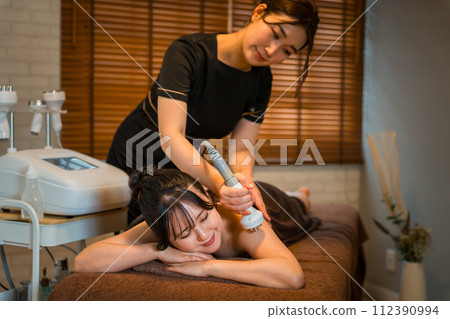 A woman receiving slimming beauty treatment at an Asian-style beauty salon/relaxation salon (esthetic machine/spa) 112390994