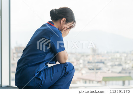 Female nurses, nurses, doctors, and caregivers crying in the hospital (medical mistakes, end-of-life care, sadness, harassment) Female nurses, nurses, doctors, and caregivers crying in the hospital (medical mistakes, end-of-life care, sadness, harassment) 112391170