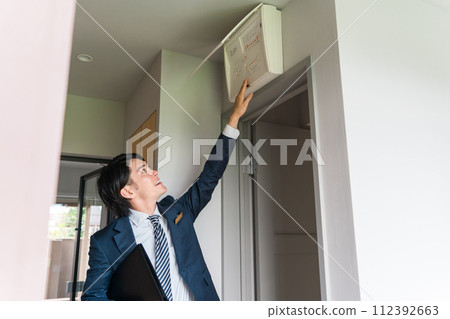 一位來自房屋建築商的男性商人解釋配電盤、配電板和斷路器 112392663