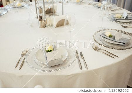 Cutlery and dishes on the table for guests at a wedding dinner in a restaurant 112392962