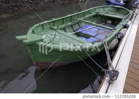 Detail of old abandoned boat on a dock in the sea 112393288