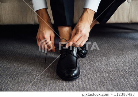 Man ties his black shoes. Close-up view 112393483