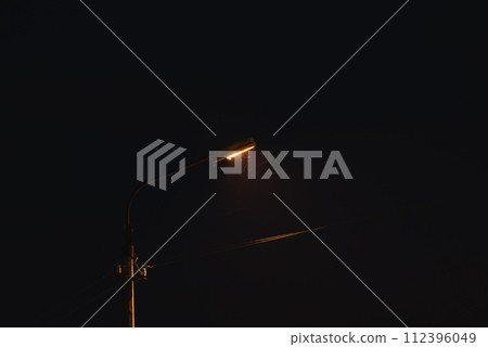 Old street lamp at night. A lantern illuminates the street in the evening. Moths fly to the light of a lantern 112396049