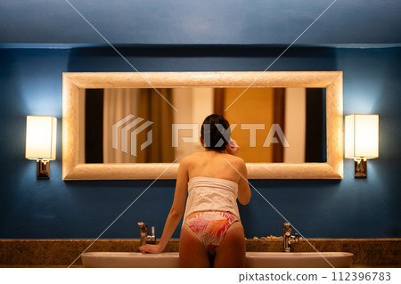 穿著泳衣的女人站在鏡子前 穿著泳衣的女人站在鏡子前 112396783