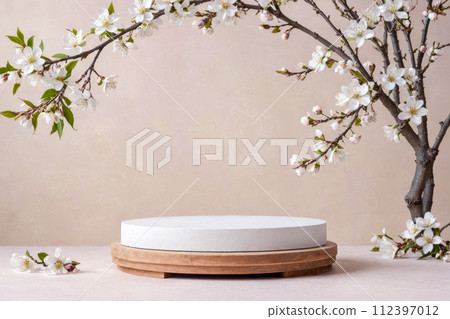 Spring theme product podium surrounded by blossoming white flowers on branches. Pastel background, wooden base and white surface of podium, showcasing items in fresh, vibrant, and seasonal context Spring theme product podium surrounded by blossoming white flowers on branches. Pastel background, wooden base and white surface of podium, showcasing items in fresh, vibrant, and seasonal context 112397012