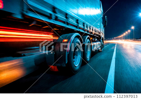 auto transportation logistics. large truck speeds along a highway at night, illuminated by bright streetlights, efficiency and speed of modern logistics and freight transportation auto transportation logistics. large truck speeds along a highway at night, illuminated by bright streetlights, efficiency and speed of modern logistics and freight transportation 112397013