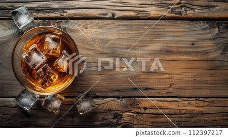 Whiskey with ice on a wooden table, viewed from above. Whiskey with ice on a wooden table, viewed from above. 112397217