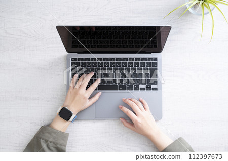 Working on a computer while wearing a smartwatch 112397673