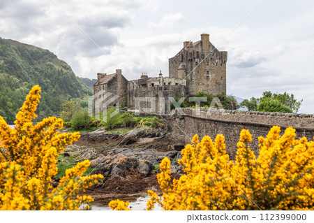 Eilean Donan Castle stands majestic against Scottish lands, with vibrant golden gorse bloom Eilean Donan Castle stands majestic against Scottish lands, with vibrant golden gorse bloom 112399000