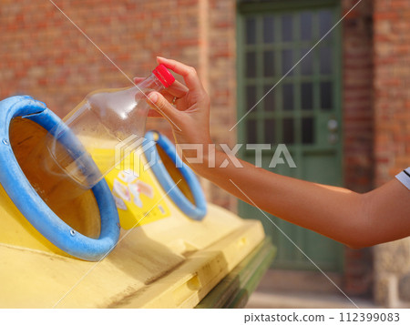 woman throwing plastic bottle Recycling bin stand on european street. Waste separation rubbish before drop to garbage bin to save world, environment care. Pollution trash recycling management concept woman throwing plastic bottle Recycling bin stand on european street. Waste separation rubbish before drop to garbage bin to save world, environment care. Pollution trash recycling management concept 112399083