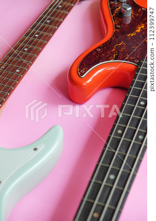 Electric guitar and bass guitar on a pink background Electric guitar and bass guitar on a pink background 112399747