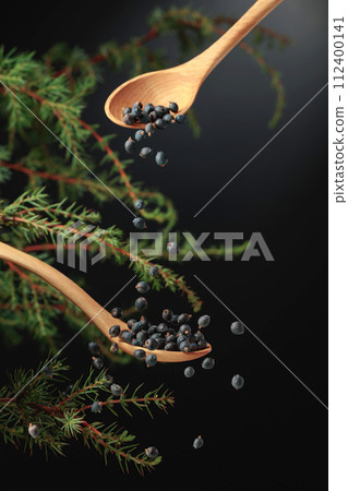 Juniper seeds are sprinkled with a wooden spoon. 112400141