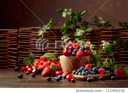 Berries closeup colorful assorted mix of strawberry, blueberry, raspberry and sweet cherry on a old wooden table. Berries closeup colorful assorted mix of strawberry, blueberry, raspberry and sweet cherry on a old wooden table. 112400142