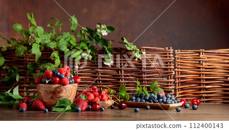 Berries closeup colorful assorted mix of strawberry, blueberry, raspberry and sweet cherry on a old wooden table. Berries closeup colorful assorted mix of strawberry, blueberry, raspberry and sweet cherry on a old wooden table. 112400143