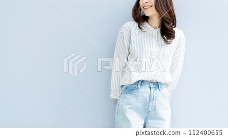 Smiling woman standing in front of a wall 112400655