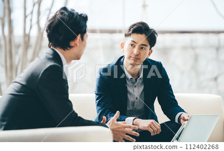 Two male businessmen having a meeting using a computer Two male businessmen having a meeting using a computer 112402268