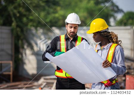 Construction civil engineer man and woman African American checking quality of work in construction. Construction civil engineer man and woman African American checking quality of work in construction. 112403432