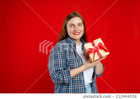 Portrait of cheerful, happy woman receive gift, smiling excited. Girl holding wrapped present, celebrating birthday on red background. Valentine's Day Women's Day birthday holiday concept. 112404558