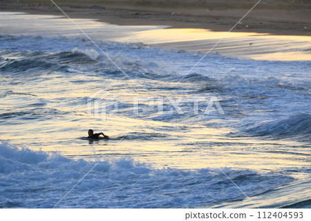 Surfer practicing at dusk Surfer practicing at dusk 112404593