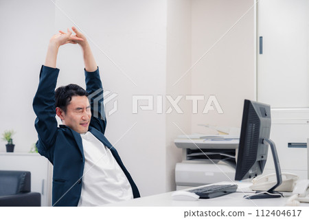 A businessman who is tired and stretches A businessman who is tired and stretches 112404617