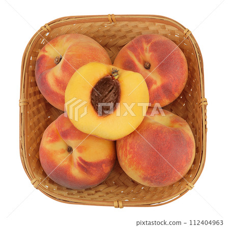 Ripe peach fruit with half in a wicker basket isolated on white background with full depth of field. Top view. Flat lay Ripe peach fruit with half in a wicker basket isolated on white background with full depth of field. Top view. Flat lay 112404963