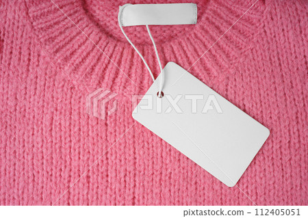 Blank clothing tag and inner label on neck of pink knitted sweater background Blank clothing tag and inner label on neck of pink knitted sweater background 112405051