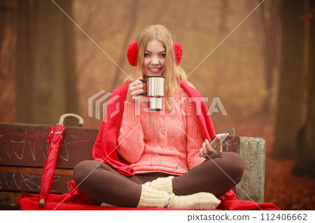 Young woman holding thermal mug. 112406662